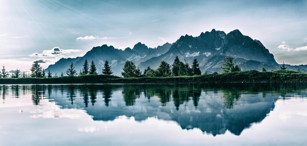 Stunning mountain landscape reflected in a serene lake under a clear sky.